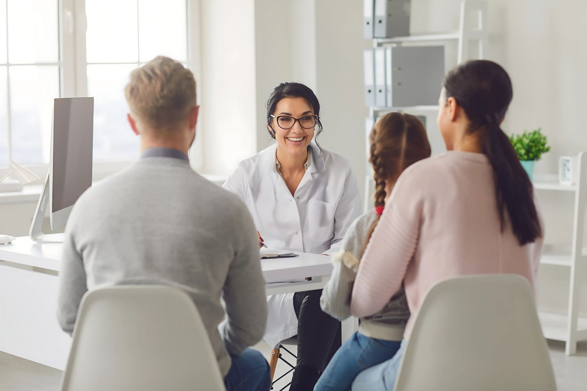 Pessoa acompanhado por um familiar durante uma consulta auditiva, enquanto um fonoaudiólogo explica sobre aparelhos auditivos. A imagem representa a importância do apoio familiar na adaptação à perda auditiva.